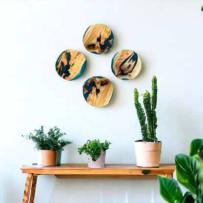 Set of Epoxy Resin Art Pieces Displayed on Wall Above Wooden Shelf with Plants